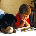 nino-y-perro-sobre-una-cama
